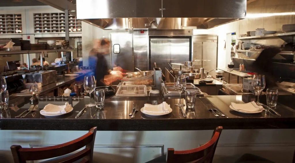 Busy kitchen scene with bar seating 